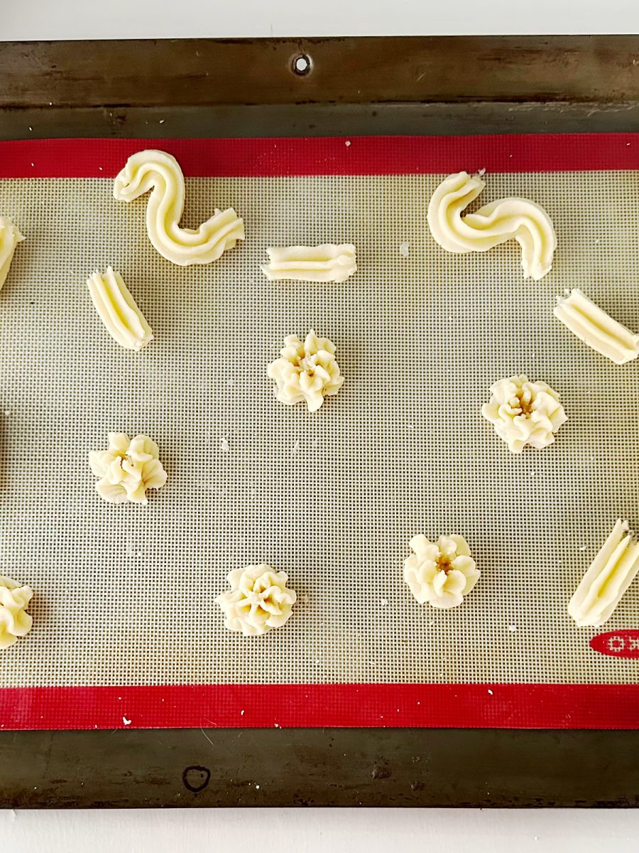 dough pressed into shapes on baking sheet